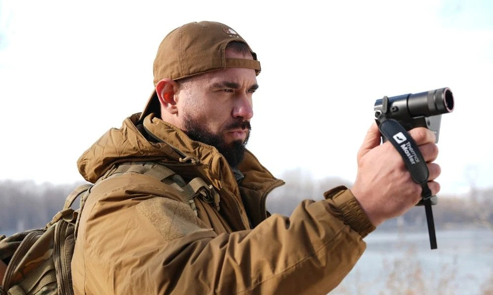 Man using the Thermal Master DV2 thermal imaging device for outdoor wildlife observation.