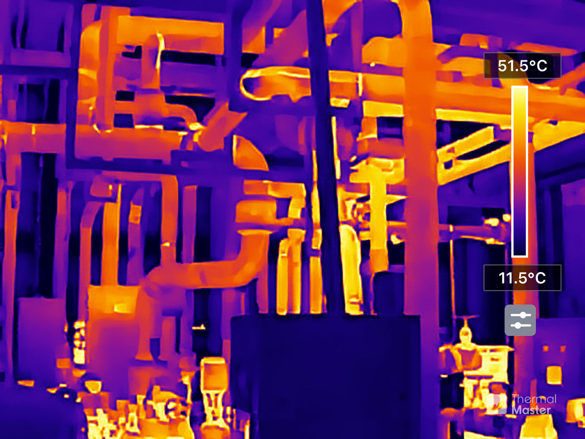 Thermal image of industrial equipment showing temperature differences across pipes and components.