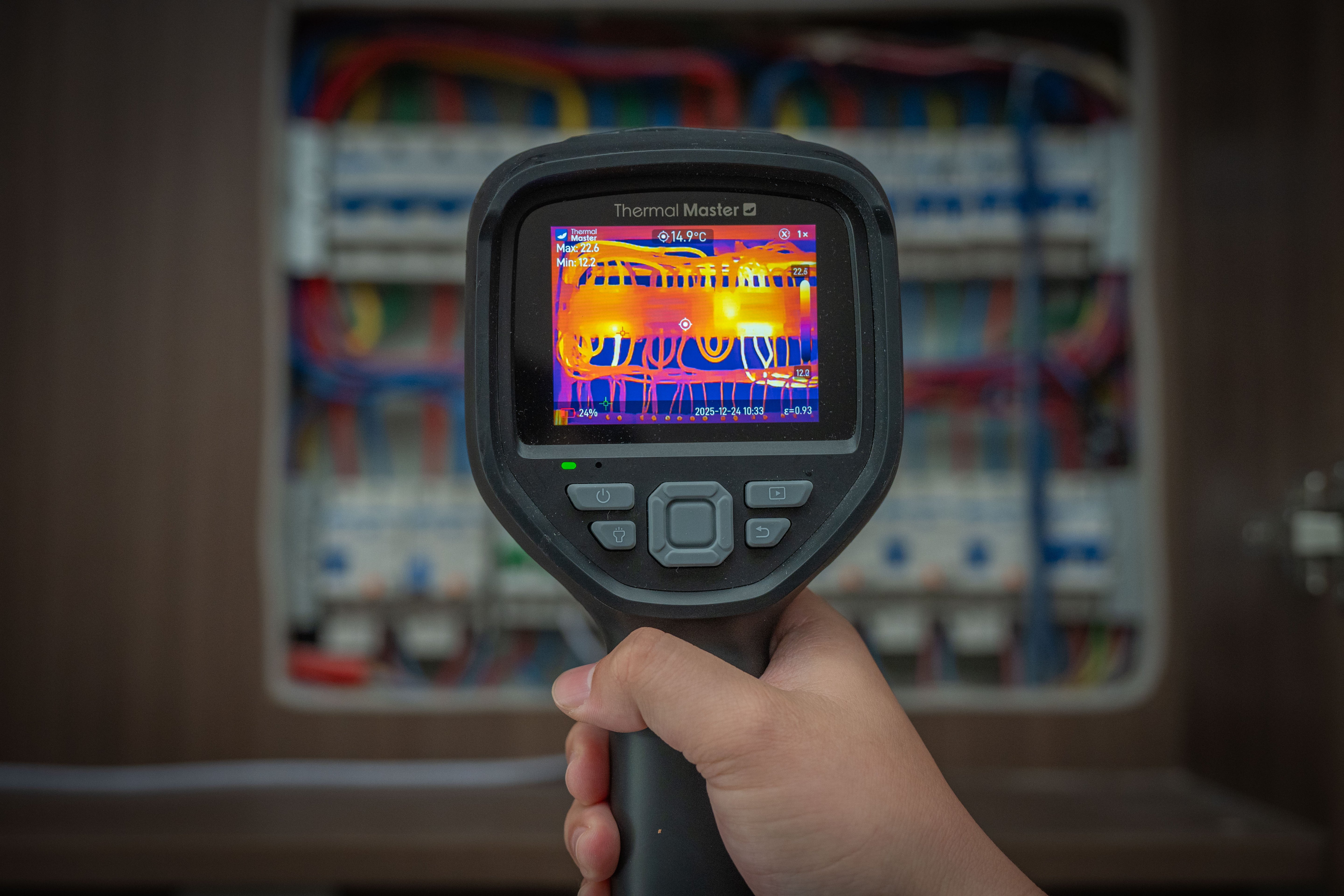 Thermal Master Thor handheld camera inspecting an electrical panel with thermal imaging.