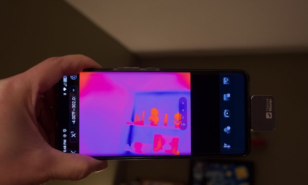Using a mobile phone thermal imager to inspect the cabinet.