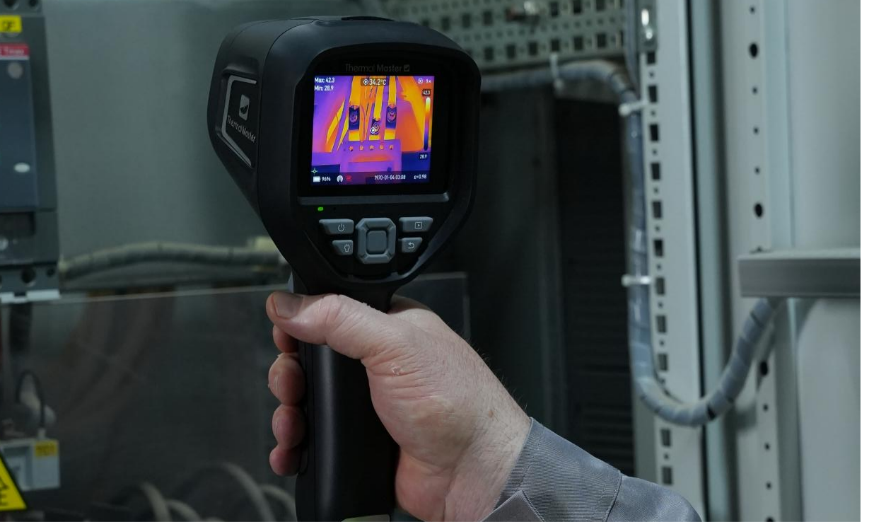 Using a handheld thermal imager to inspect the circuit.