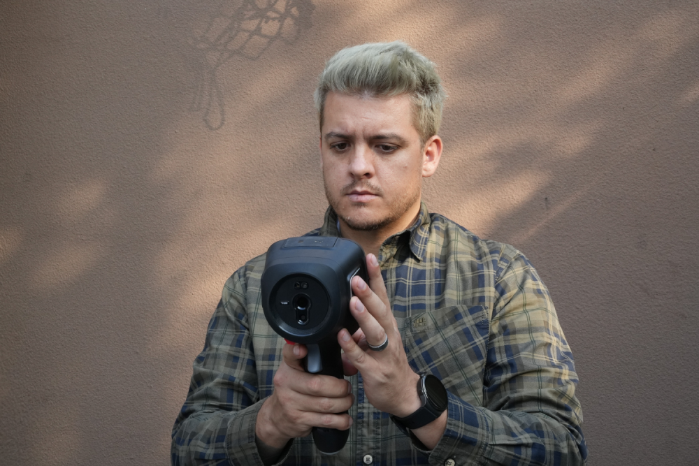 Technician operating a Thermal Master handheld thermal camera during a building inspection.