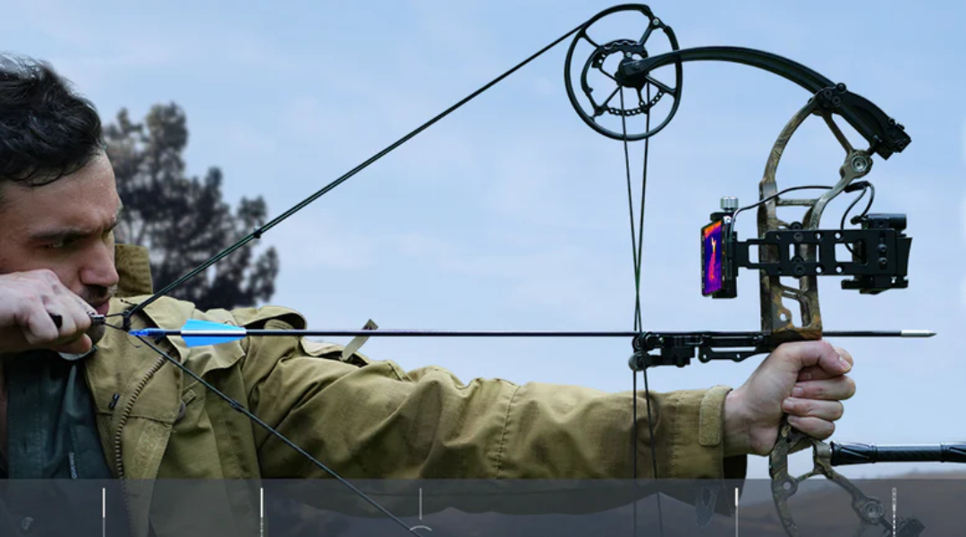 A man mounts thermal monoculars onto a crossbow.